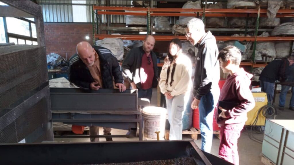 Jovens do Instituto Alce em visita técnica a empresa de reciclagem, aprendendo sobre inclusão produtiva e organização de produção industrial.
