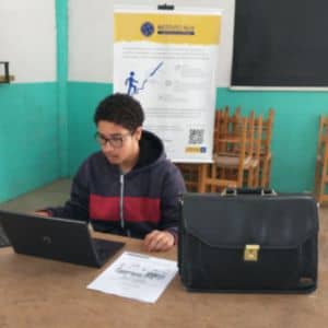 Jovem aluno em aula de empreendedorismo de impacto com notebook, no projeto do Instituto Alce em Farroupilha, Serra Gaúcha.