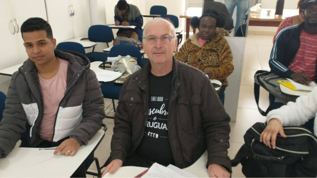 Alunos adultos, incluindo idoso e refugiados haitianos e venezuelanos, em aula de escolaridade na adultez no Instituto Alce.