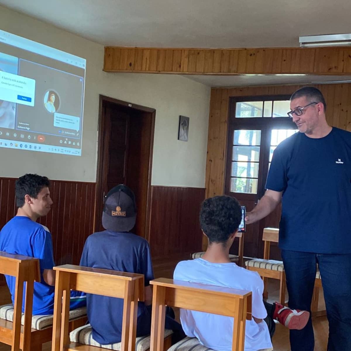 Imagem do programa de mentoria de carreira e orientação profissional do Instituto Alce. Na cena, Guilherme Betto aparece presencialmente durante uma dinâmica com grupo reduzido de jovens, enquanto Maria Estela participa por compartilhamento de tela no Google Meet. A atividade representa a metodologia de atendimento personalizado adotada pelo Instituto, com foco em inspiração, orientação e acompanhamento próximo para o desenvolvimento de trajetórias profissionais e abertura de oportunidades.