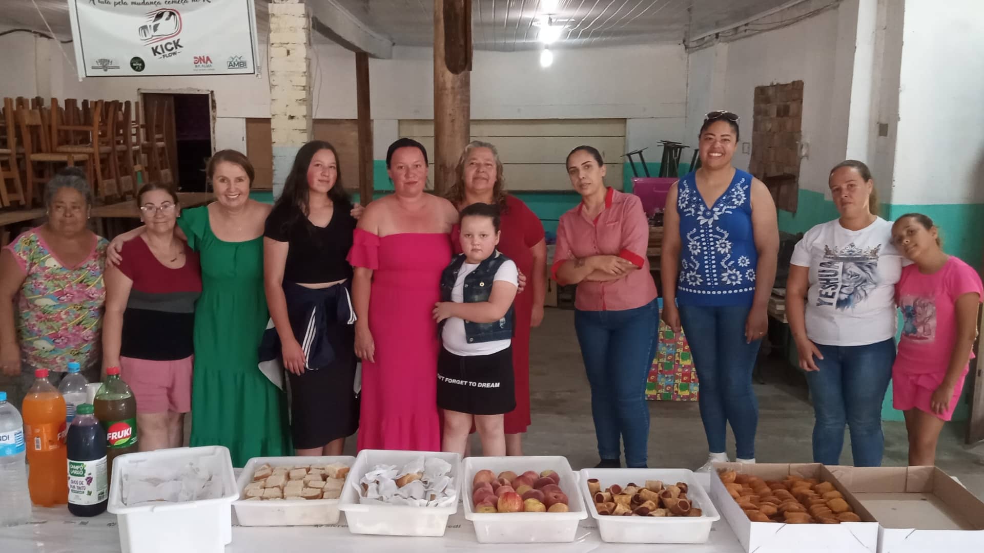 Grupo de mulheres reunidas ao final de uma atividade do projeto Elas por Elas, com lanche coletivo em mesa compartilhada