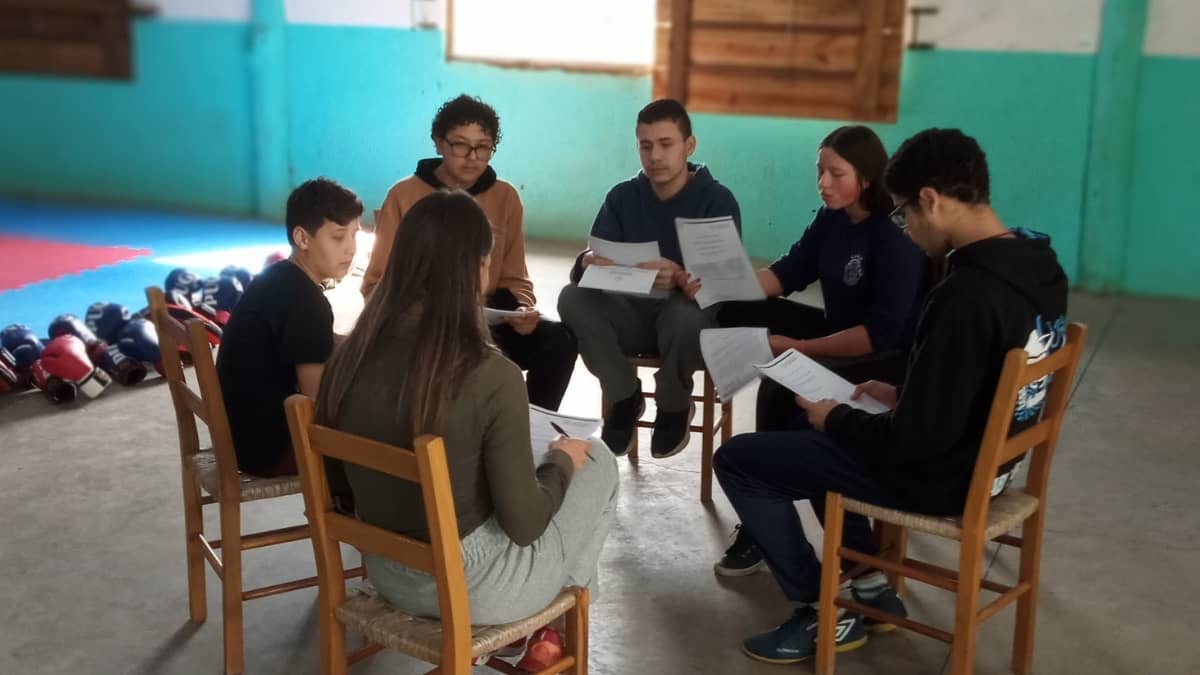 Grupo reduzido de adolescentes em roda durante dinâmica de mentoria de carreira e orientação profissional no Instituto Alce