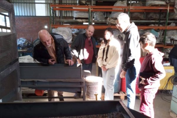Jovens do Instituto Alce em visita técnica a empresa de reciclagem, aprendendo sobre inclusão produtiva e organização de produção industrial.